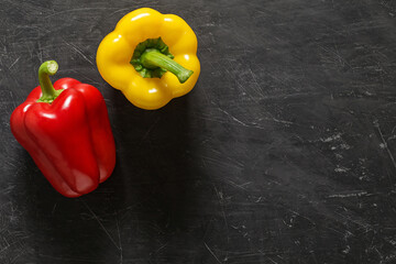 Sweet red and yellow peppers, whole top view dark background, with space to copy text.