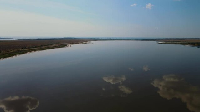 Ascent over salt lake with dead water near the sea with cloud reflection. Concept of beauty and nature conservation