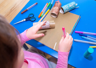 Children's creativity. A 5-year-old child, Caucasian, makes crafts from cardboard and paper. The development and upbringing of the child.