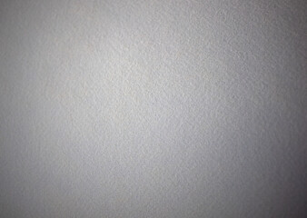 Photo of a white texture made of felt fabric. Pure grey felt background.