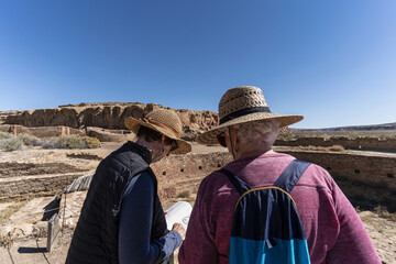 USA, New Mexico, Chaco Canyon National Historic Park, Rear view of two women at Chetro Ketl archeological site