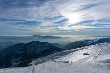 Valley of hilghland mountain winter resort on bright sunny day. Panoramic wide view of downhill slopes
