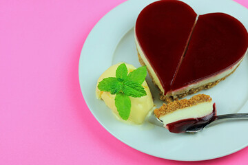 fresh mint on a scoop of vanilla ice cream with a broken heart shaped raspberry cheesecake.