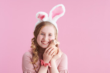 Obraz na płótnie Canvas happy stylish child with long wavy blond hair on pink