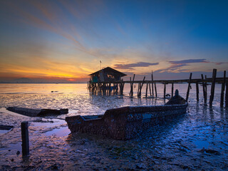 sunset on broken fishing boat