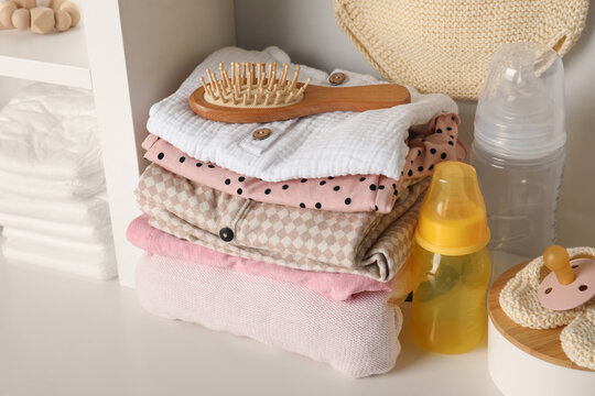 Baby clothes and accessories on white rack