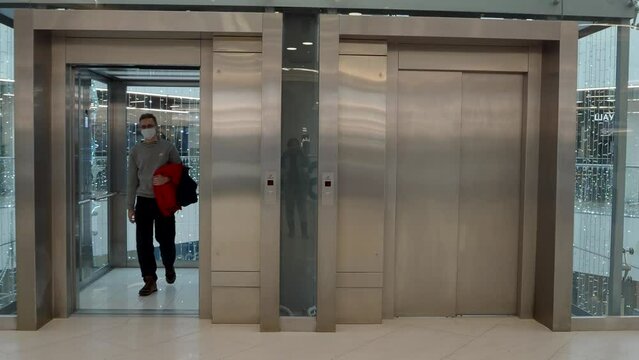 Modern elevator in a shopping or business center. A young man comes out of the elevator. High quality 4k footage