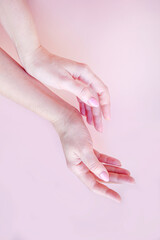 well-groomed female hands on a pink background