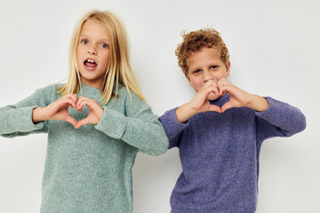 Portrait of cute children gesticulate with their hands together isolated background