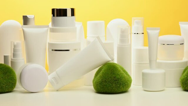 jar, bottle and empty white plastic tubes for cosmetics on a yellow background. Packaging for cream, gel, serum, advertising and product promotion