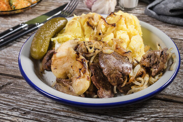Fried liver with onion and apple, served with boiled potatoes and pickled cucumber.