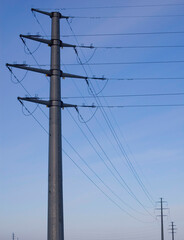 High voltage transmission tower over blue sky.