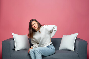 Young girl touch lower back suffer from spasm, have backache, muscle strain sitting in incorrect...