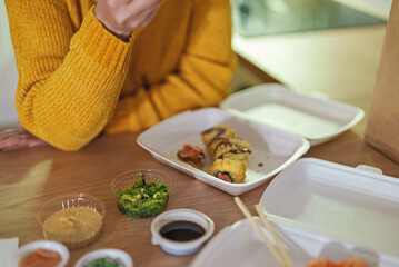 People eating take-away sushi rolls.