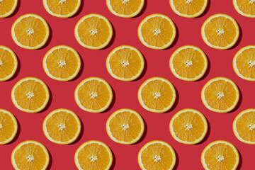 Summer composition made from oranges, on dark red  background. Creative Pattern made of slices of orange. Flat lay