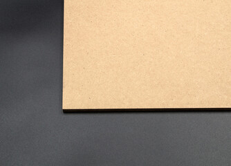 Part of a raw mdf brown board in the upper right corner of the photo, on a black background.
