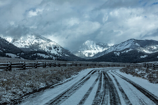 USA, Idaho, Stanley, Road between pastures in snowy mountain landscape