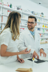 Young female pharmacist holding medications in her hand