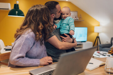 Family playing together at home while mother should be working on her laptop