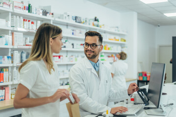 Male pharmacist working with young female colleague in a pharmacy