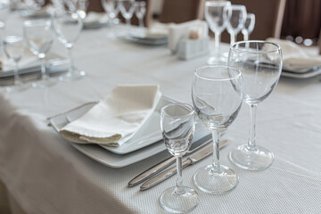 Empty table in a restaurant, served with cutlery, with a white cape