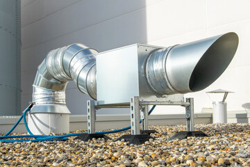 Air extractor and large galvanized steel pipes on the roof of a warehouse