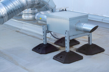 Air extractor and large galvanized steel pipes on the roof of a warehouse