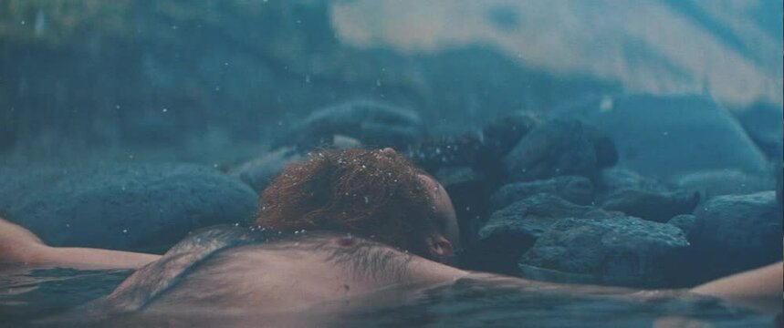 Man lays peacefully in natural spring 