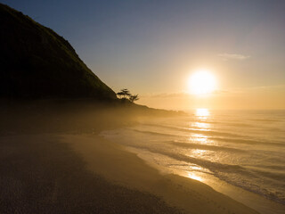 Aerial view of Prainha Beach, a paradise in the west side of Rio de Janeiro, Brazil. Big hills around. Sunny day at dawn. Greenish sea. Drone Photo
