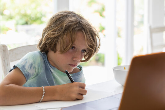 Boy (8-9) drawing picture during online lesson - Powered by Adobe