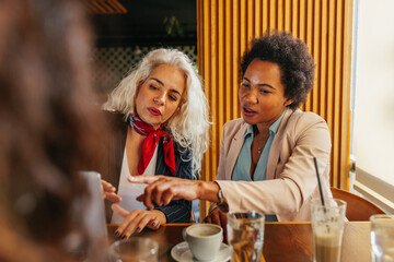 Lifelong diverse friends catching up over coffee