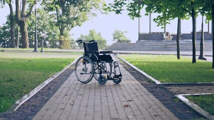 Manual wheelchair standing in park, disability rights movement, rehabilitation