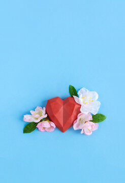 Polygonal soap heart decorated with sakura flowers. Сoncept of beginning of the feeling of love. Vertical card for Valentine's Day. Сopy space