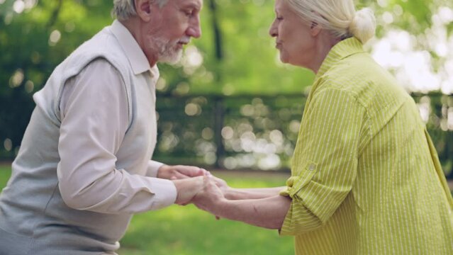 Senior man getting up from wheelchair with wifes support, recovery after surgery