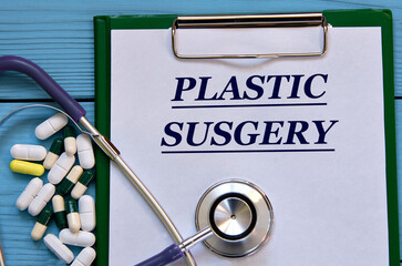 PLASTIC SUSGERY - word on a white sheet on a blue background with tablets and a stethostecop