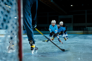 Child playing ice hockey in a protection uniform - Powered by Adobe