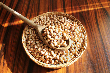 Carioa beans in a spoon and basket on the sunlight. Brazilian beans.