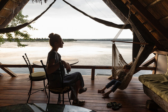 Africa, Zambia, Livingstone, Brother (8-9) and sister (16-17)&nbsp;relaxing in lodge by Zambezi River