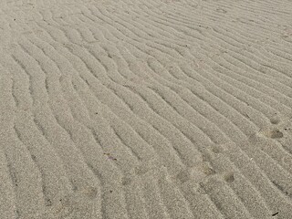 Obraz premium Wave ripples on sand creating abstract beach background