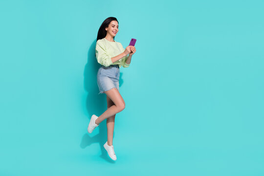 Full length photo of lady millennial jump use gadget search website discount isolated over cyan color background