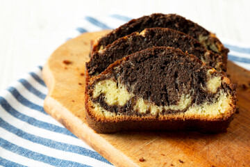 Homemade Chocolate and Vanilla Marble Cake on a rustic wooden board, side view. Close-up.