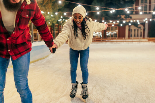 Diverse couple ice skating together
