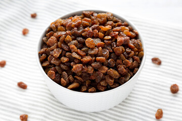 Dried Brown Raisins in a Gray Bowl, side view.