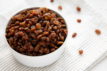 Dried Brown Raisins in a Gray Bowl, low angle view. Copy space.