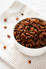 Dried Brown Raisins in a Gray Bowl, side view.