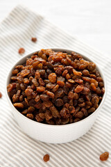 Dried Brown Raisins in a Gray Bowl, side view.