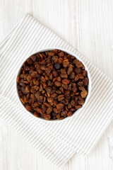 Dried Brown Raisins in a Gray Bowl, top view. Flat lay, overhead, from above.