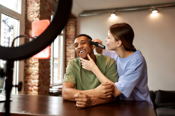 Girl shaving hair of guy for video challenge