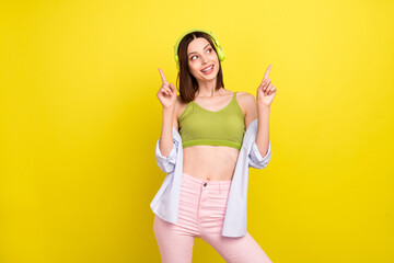 Photo of flirty bob hairdo millennial lady dance look empty space wear headphones green singlet shirt isolated on yellow background