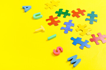 Word AUTISM with colorful puzzle pieces on color background